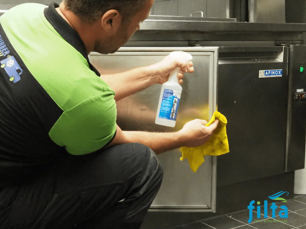 Employee cleaning fridge seal