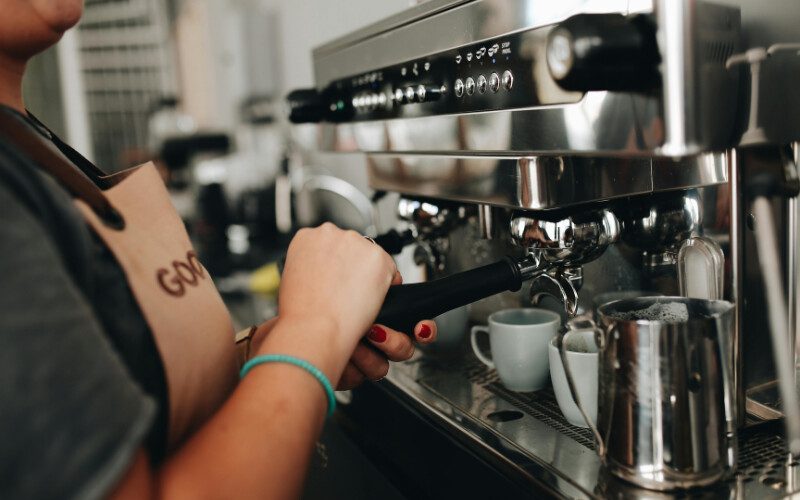 Image showcasing someone making a coffee in a commercial kitchen